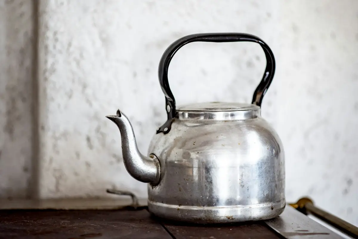 A stainless steel kettle on a wooden table