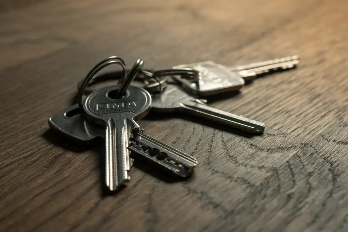 A bunch of house keys on a wooden table
