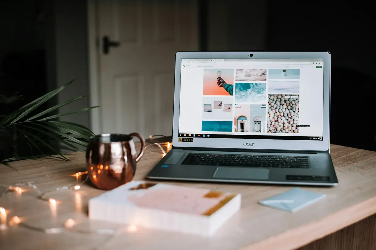 A laptop on a table next to a mug