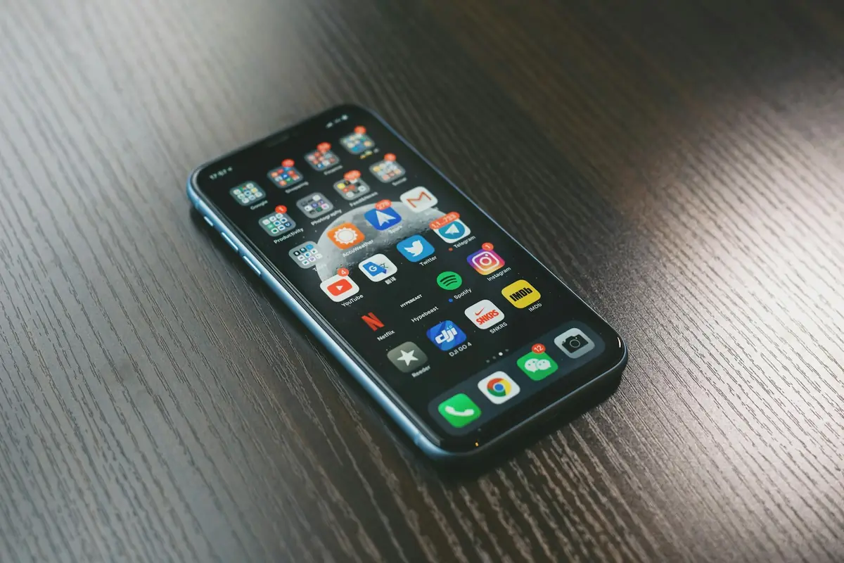 A smartphone lying on a dark wooden table