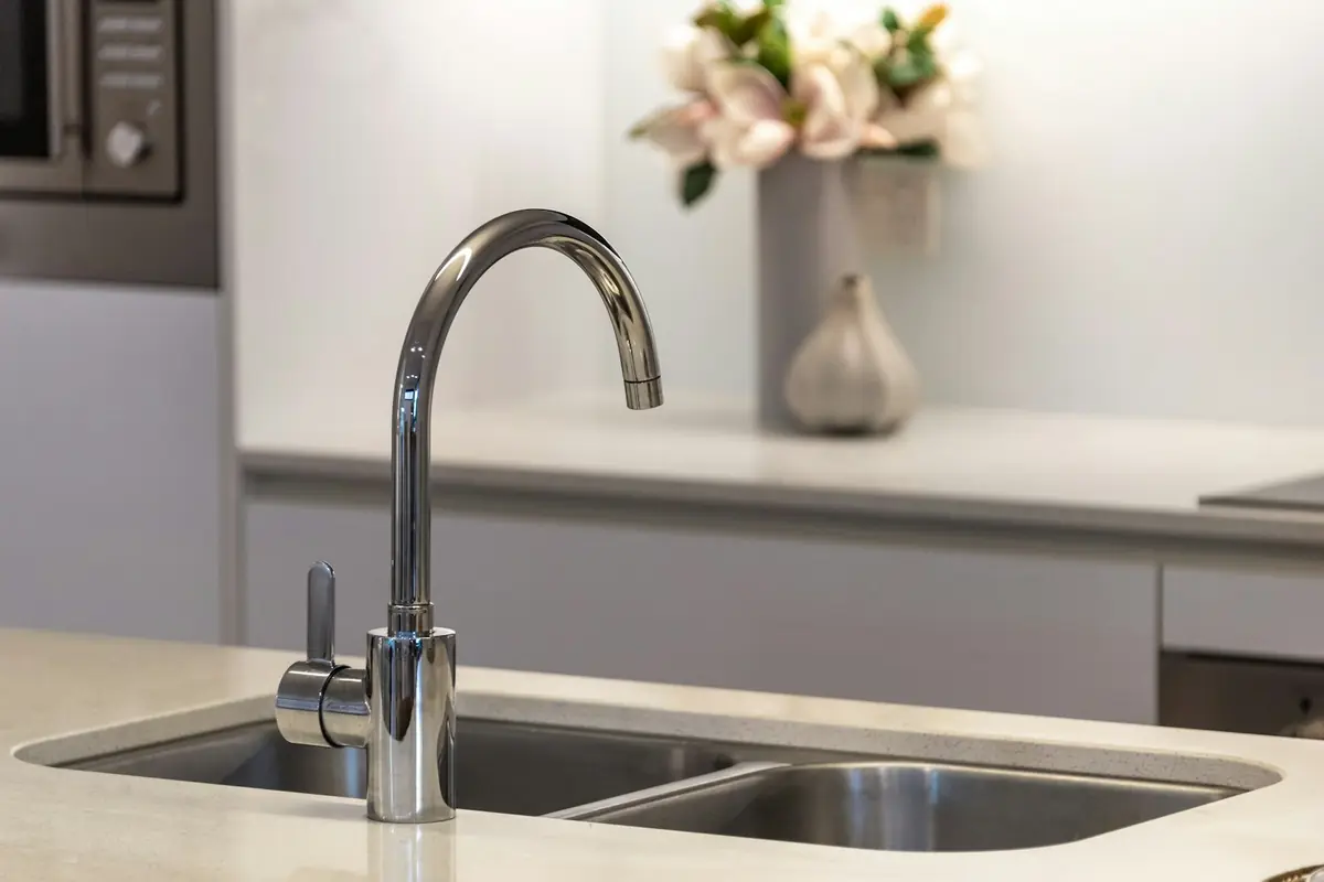 A kitchen tap over a stainless steel sink